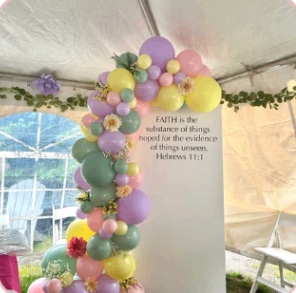 Lavender, green and yellow outdoor balloon garland on a white panel