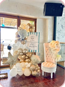 Cream and gold balloon arrangement beside a floral display