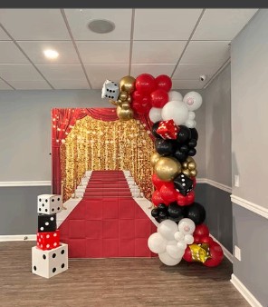 Red carpet casino-themed balloon arch for an adult birthday