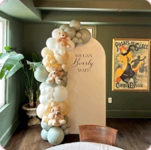 Soft cream and sage baby shower backdrop with teddy bear details