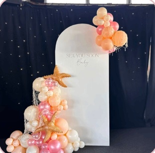 Peach and cream balloon arrangement with starfish and a white backdrop
