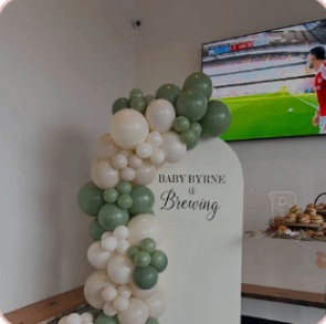 Green and white baby shower garland beside a personalized panel