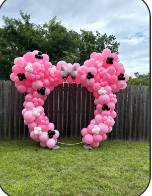 Pink bow-shaped balloon arch for a girl's birthday