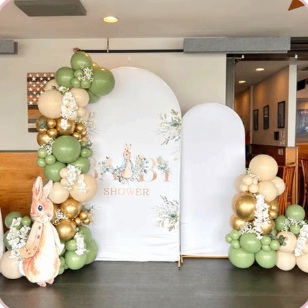 Green and gold balloon garlands with a storybook baby shower backdrop