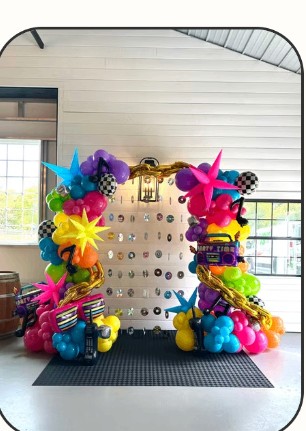 Vivid multicolor balloon arch with themed props