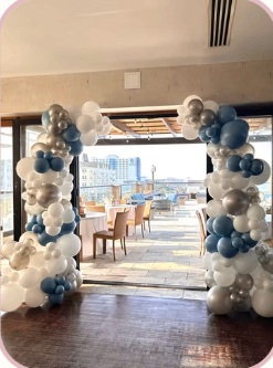 Blue, white and silver balloon columns framing a venue entrance