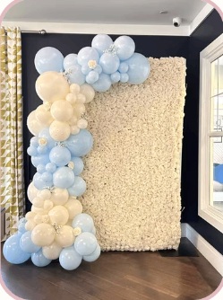 Pastel blue and cream balloon garland framing a flower wall