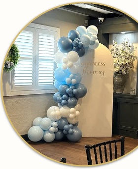 Blue and white balloons framing a God Bless backdrop