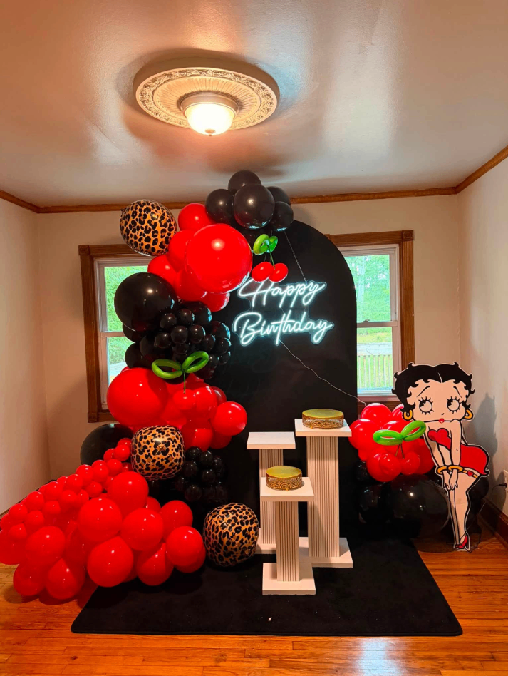 Red, black and leopard balloon arch with a glowing happy birthday sign