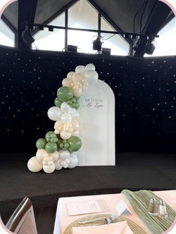 Sage and ivory balloon garland on an elegant stage backdrop