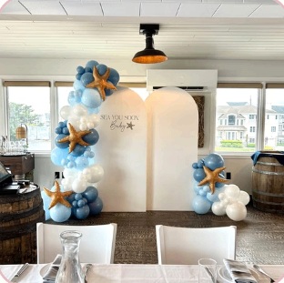 Blue and ivory baby shower balloons with starfish accents and arched backdrops